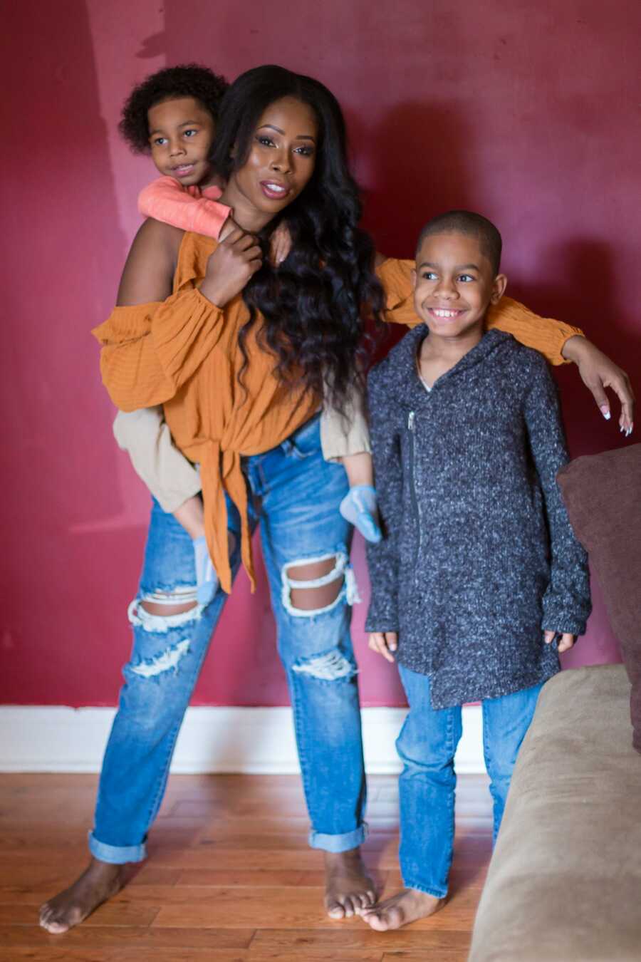 Single mom with her arm around oldest son smiles for picture together. 