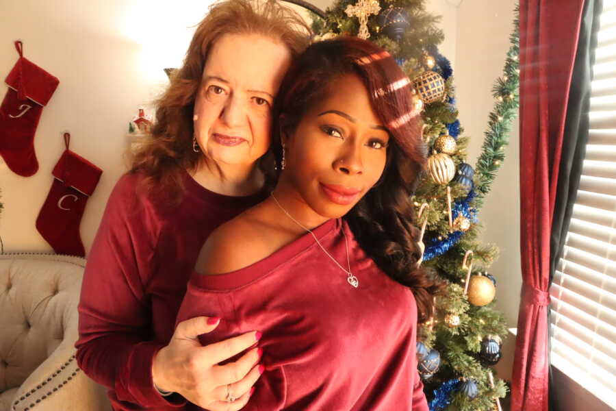 New mom and adopted adult daughter take picture in matching pajamas.