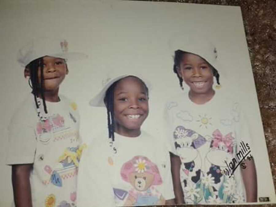 Biological sisters adopted together from foster care wear cartoon shirts and white hats.