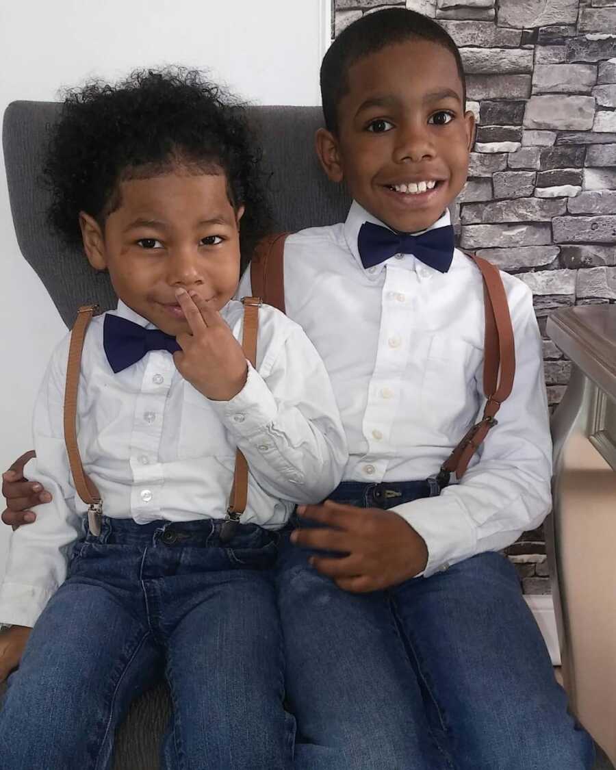 Boys of single mom sit side by side wearing white shirts and bow ties. 