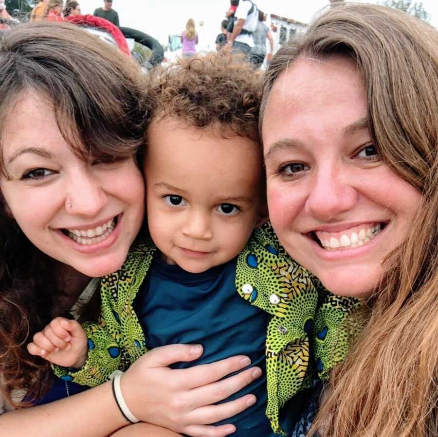 A single mom and her son stand with another woman. All three are near the camera.