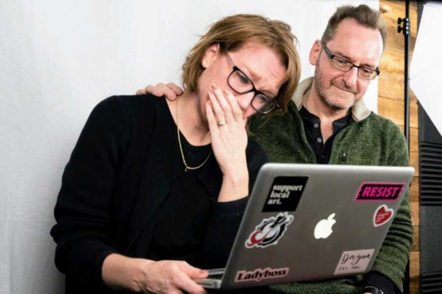 wife and recovered alcoholic husband sit in front of laptop emotional