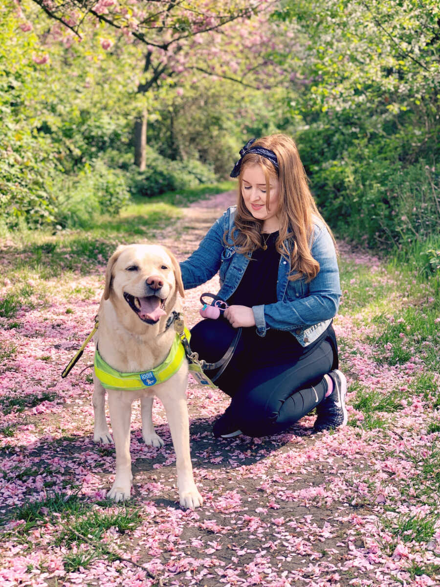 woman and her guide dog posing in flowers