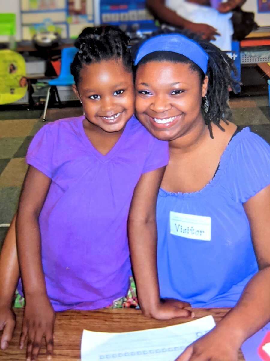 teen mom poses with her daughter while in a classroom