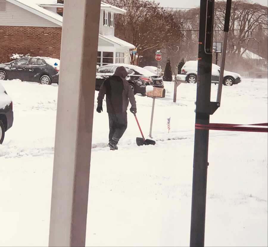 man shoveling neighbors driveway because they are too old