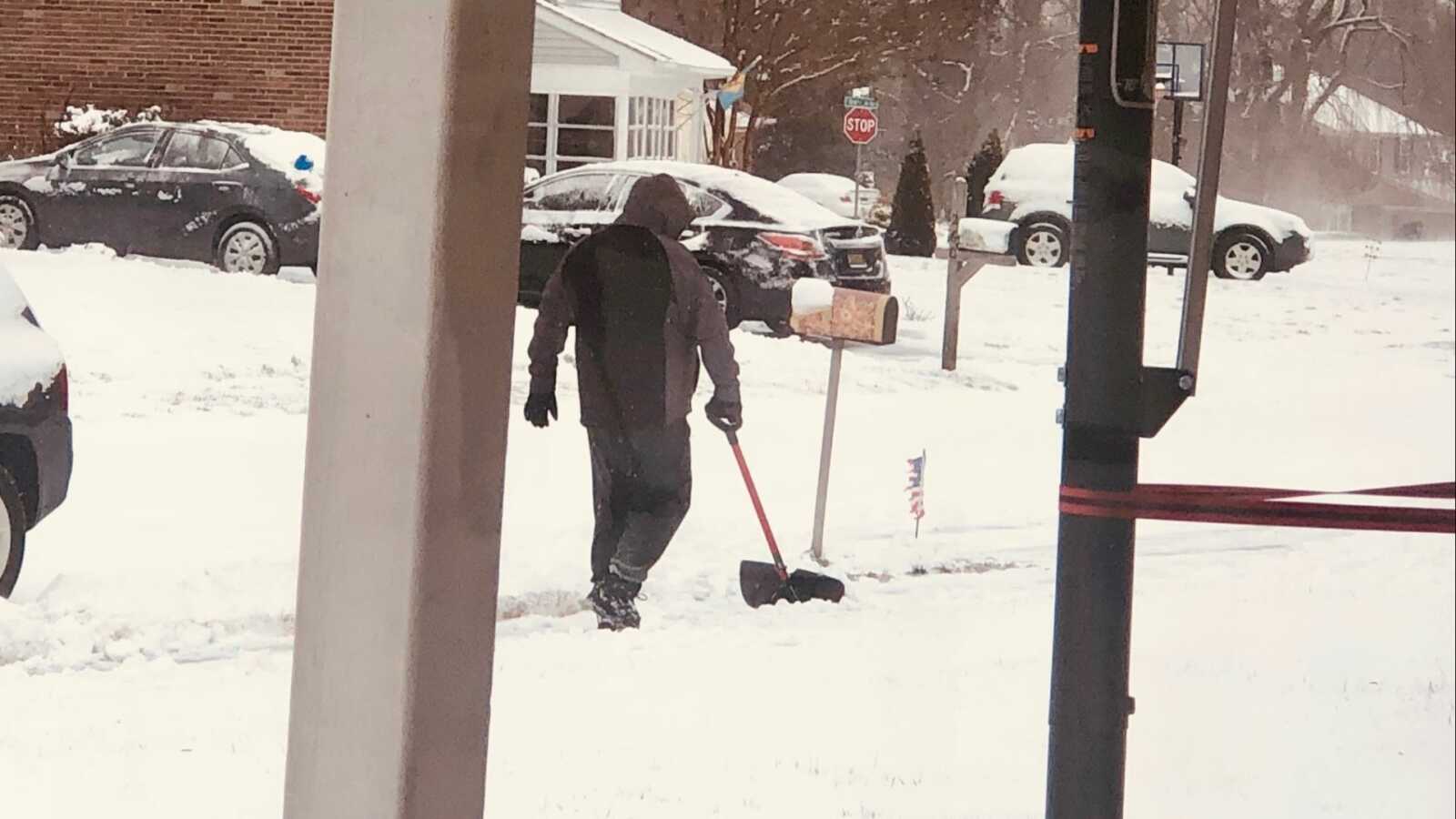 man shoveling neighbors driveway because they are too old