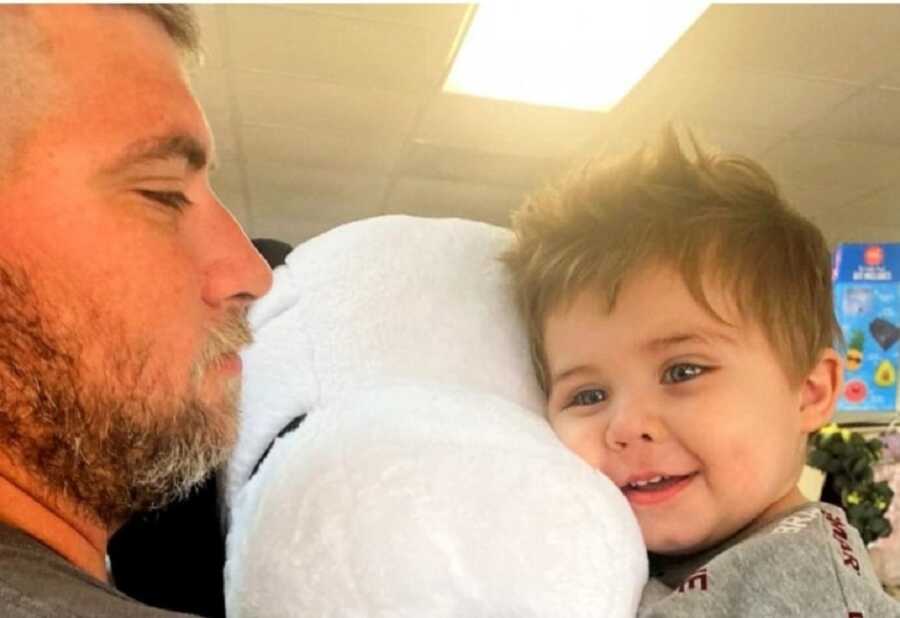 Toddler who saved family from house fire hugs white stuffed animal.