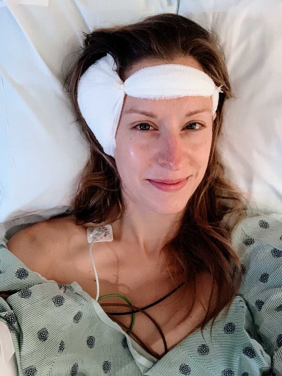 woman in hospital bed after brain surgery with a bandage around her head