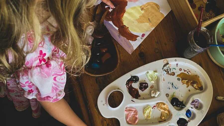 little girl makes a mess with watercolor paints