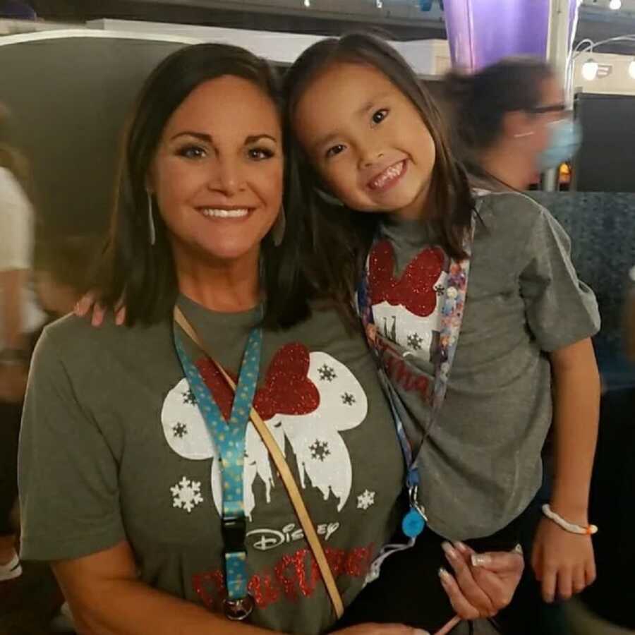 adoptive mom and internationally adopted daughter take picture in matching Disney shirts