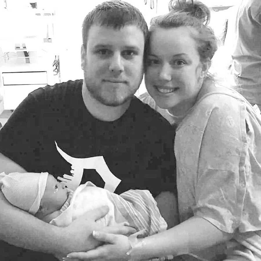 couple sits in the hospital holding their newborn child