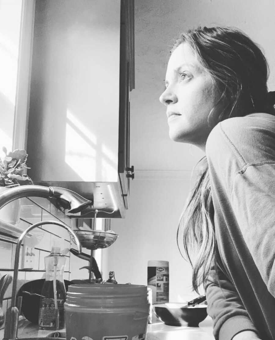 woman in her kitchen looking out the window