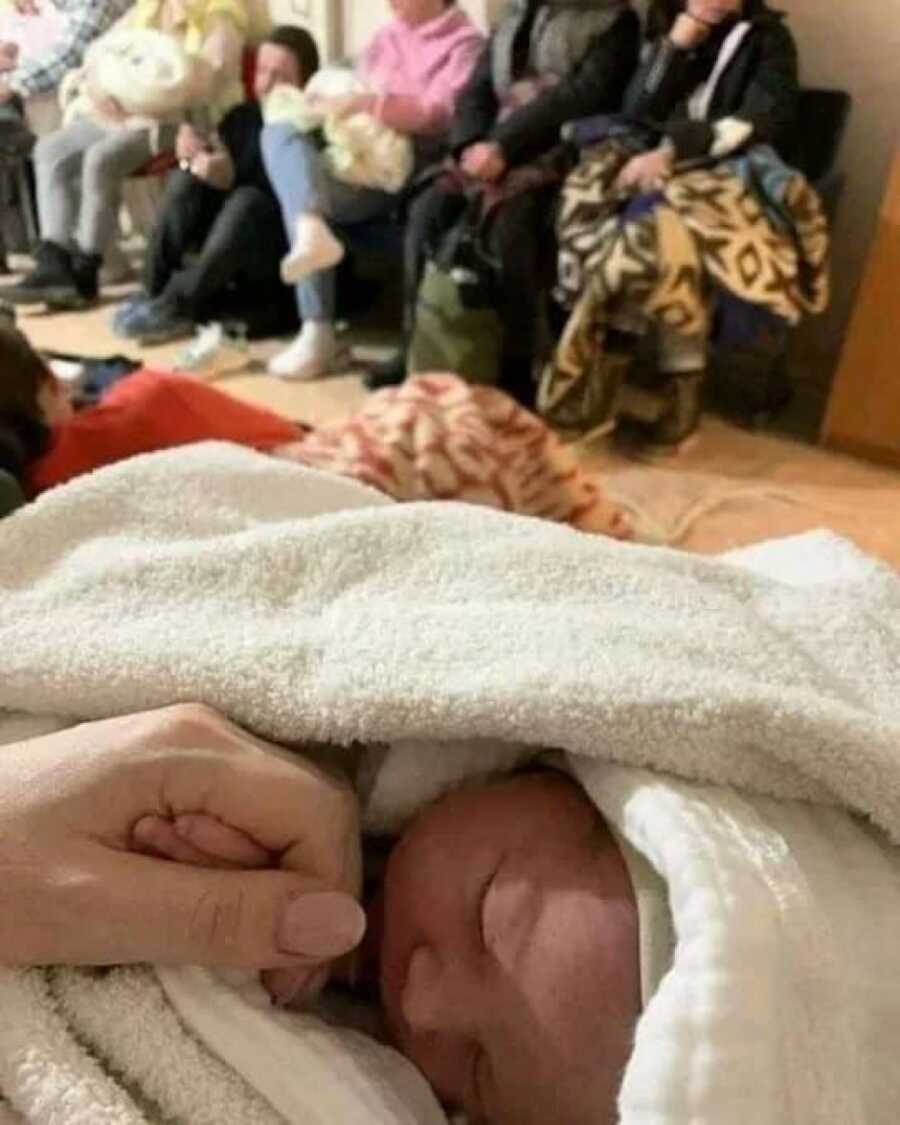woman holding her new born baby's hand