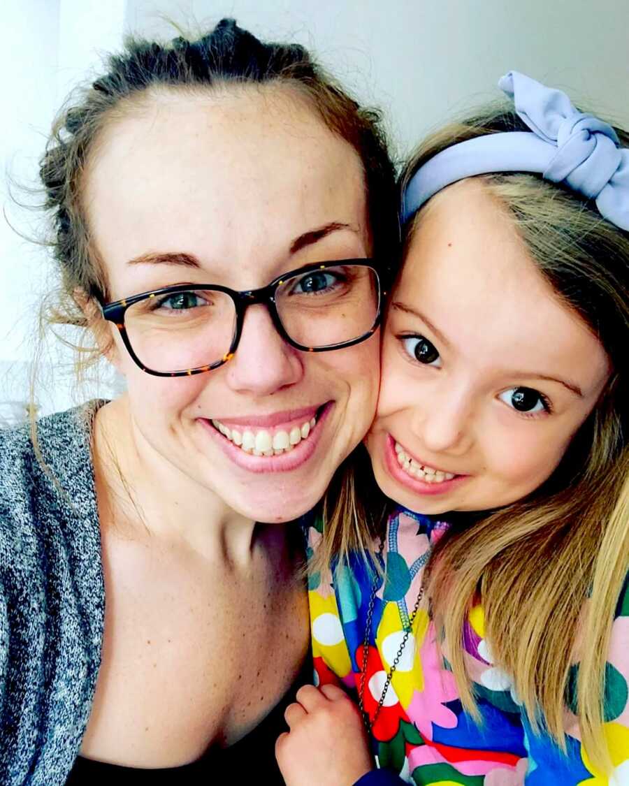 mother takes a selfie with her daughter, both are smiling wide