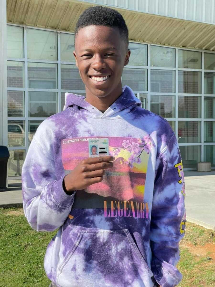 son with his driver's license smiling at the camera