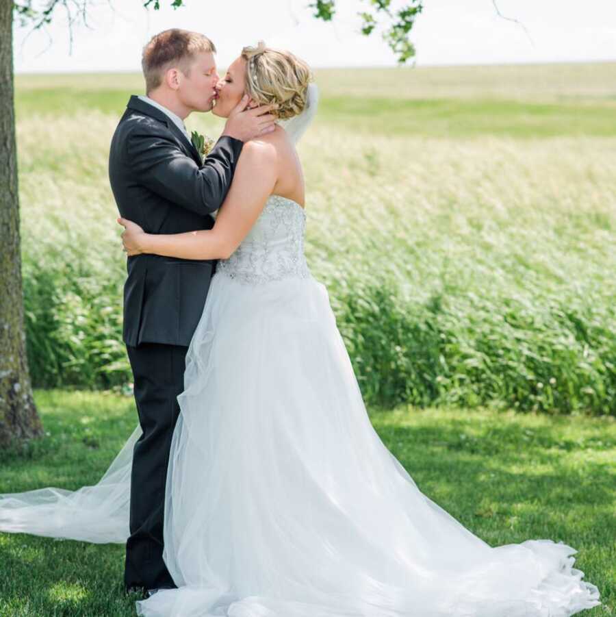 man and wife kissing on their wedding day