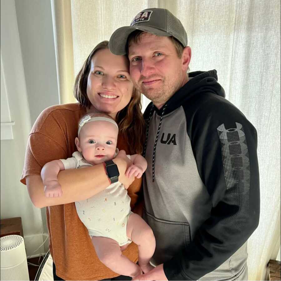 mom and dad smiling with their new baby girl