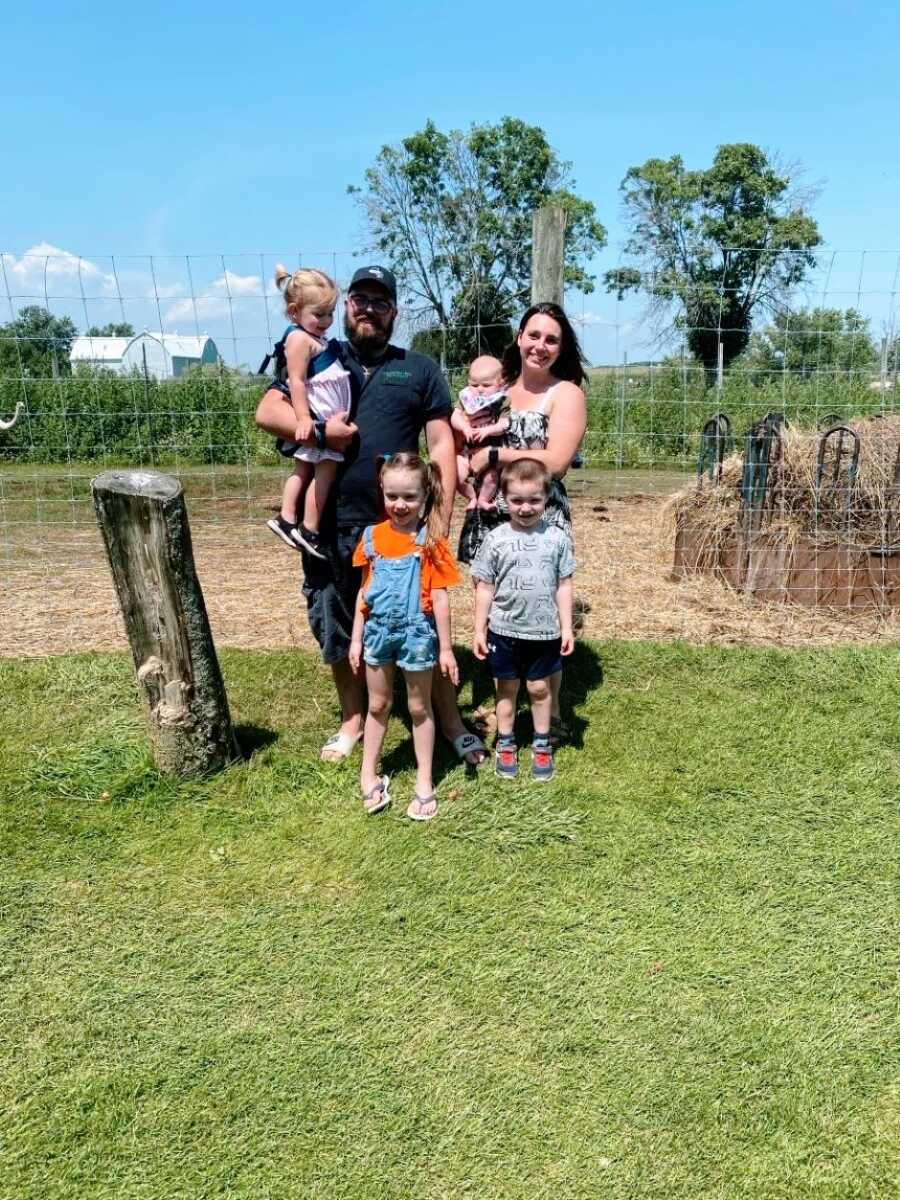 Family of six take a photo while enjoying some sun on a farm