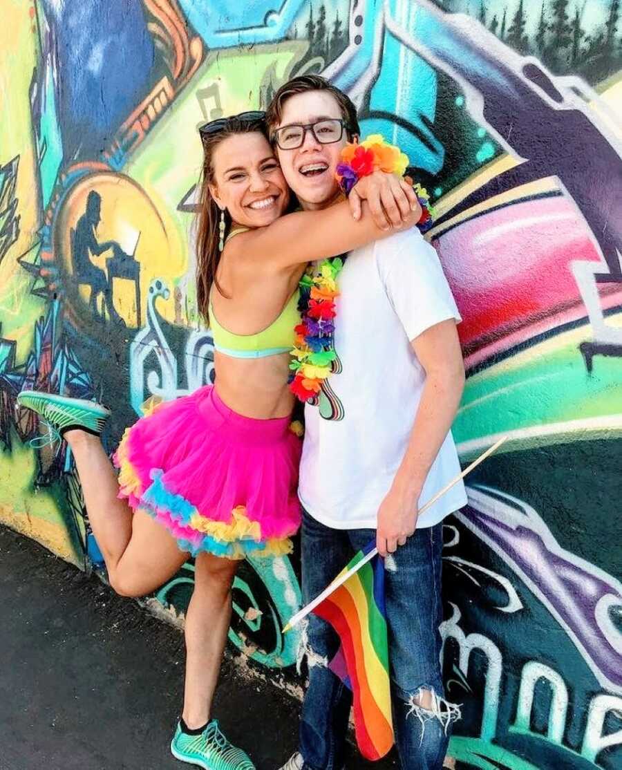 Mom hugs her transgender daughter while attending a pride event decked out in colorful pride gear