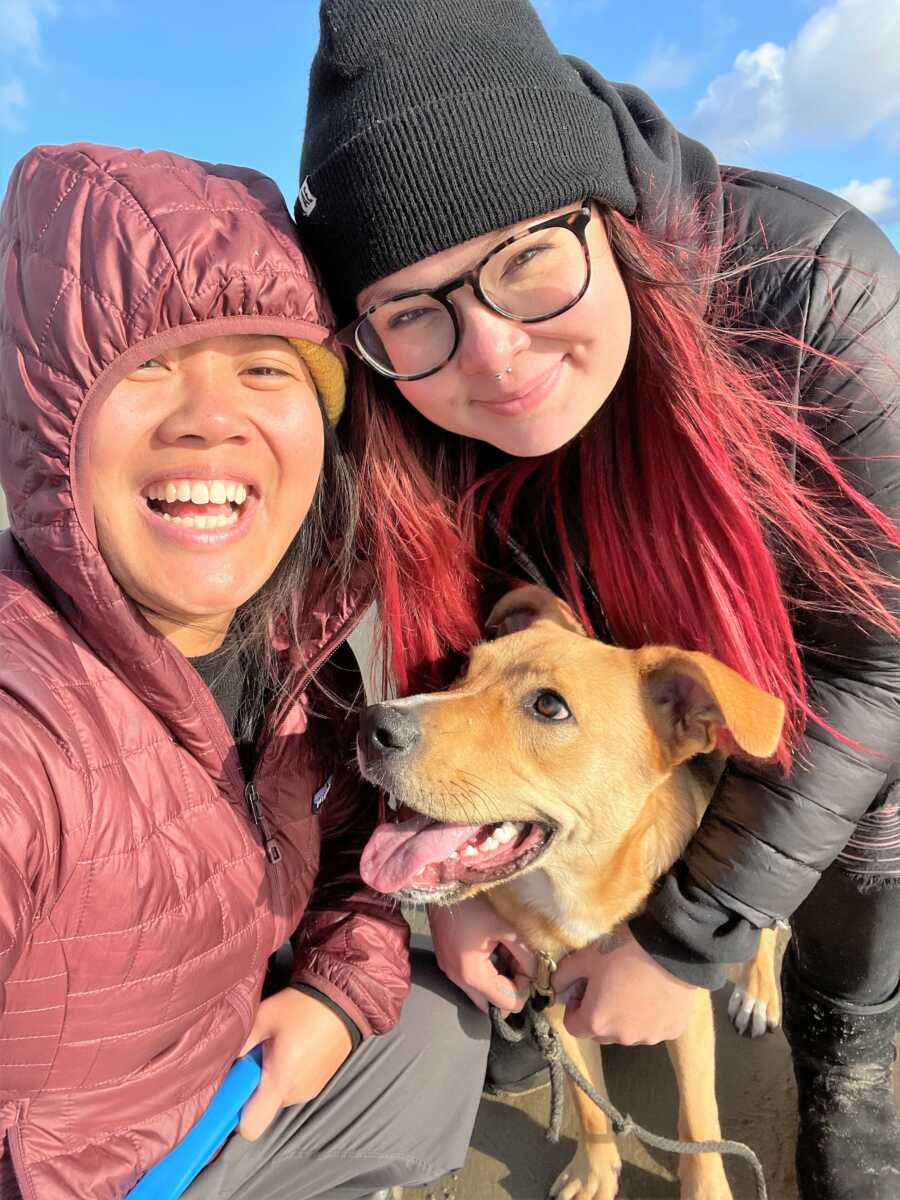 selfie of LBGT couple smiling next to their rescued dog
