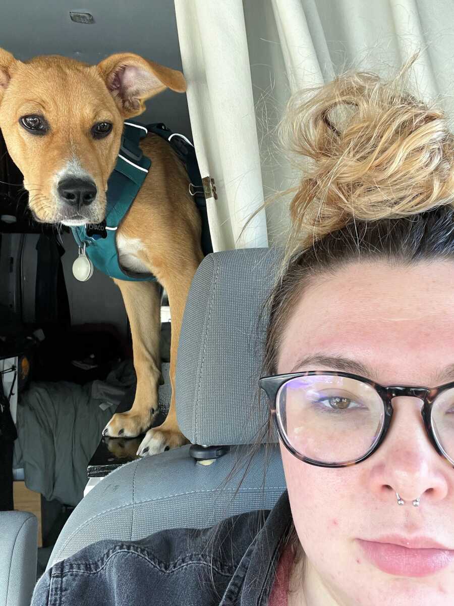 woman driving a camper van next to her rescued dog