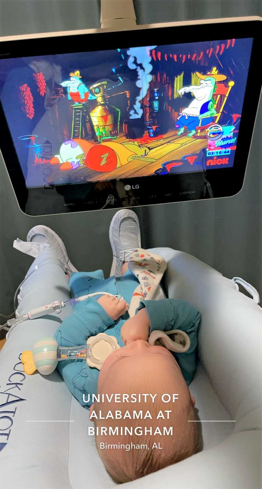 baby boy receiving chemotherapy while watching cartoons on the tv 