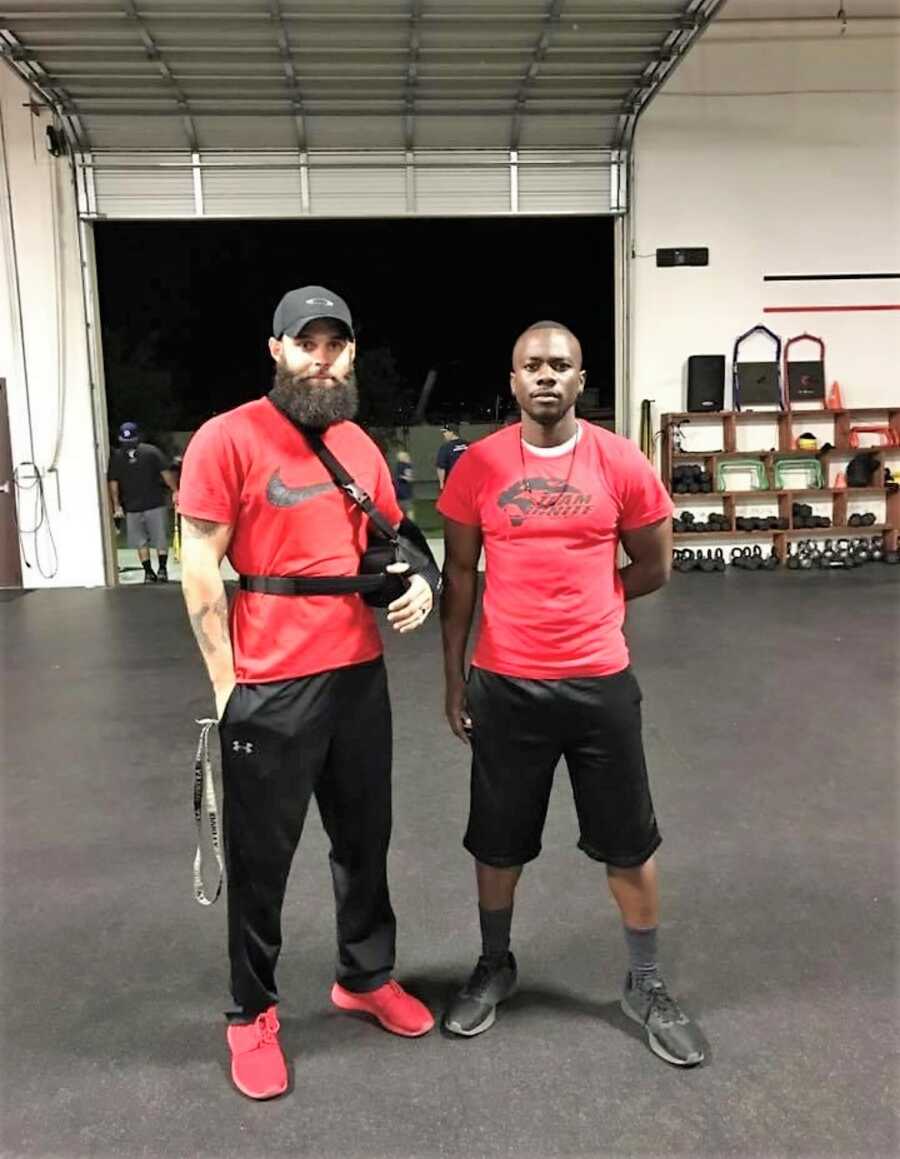 two man at the gym wearing matching red shirts