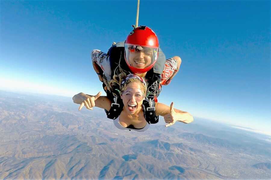 excited young woman skydiving with the assistance of a licensed professional