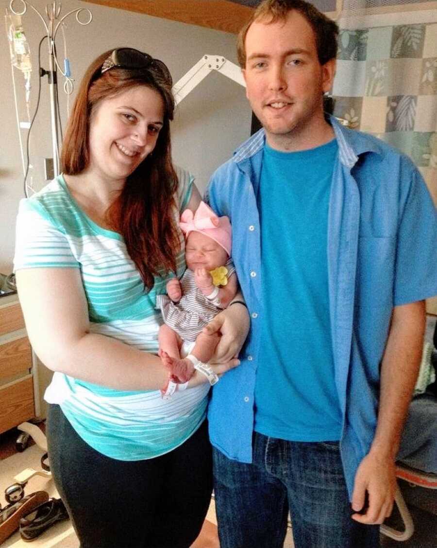 Birth mom and dad take a photo in the hospital with their newborn daughter before giving her up for adoption