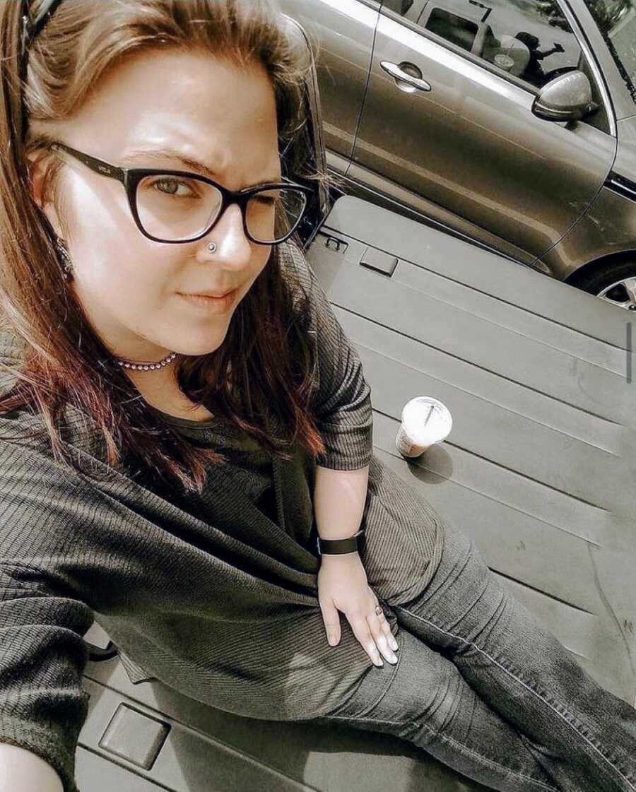 Birth mom takes a selfie while drinking coffee in the bed of a truck