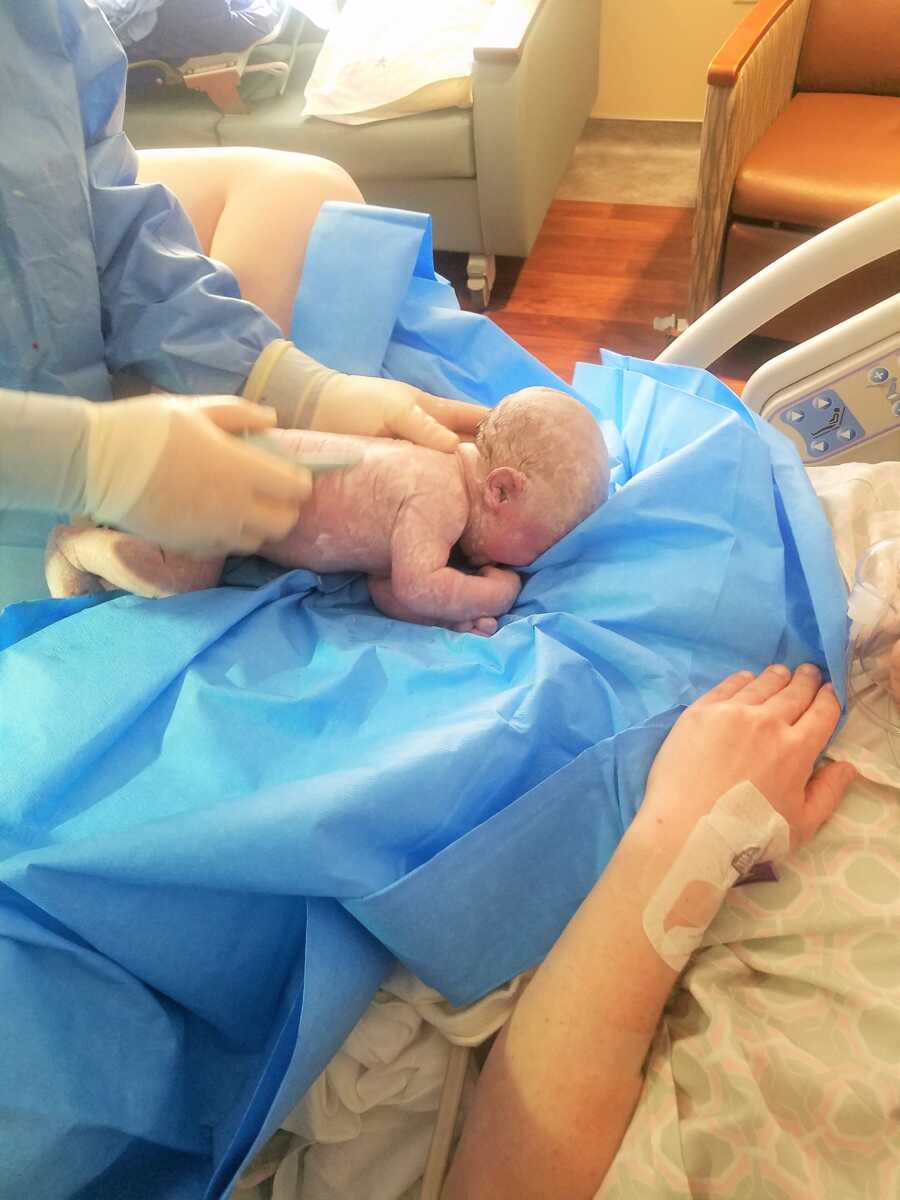 newborn baby girl covered in placenta fluids right after birth 