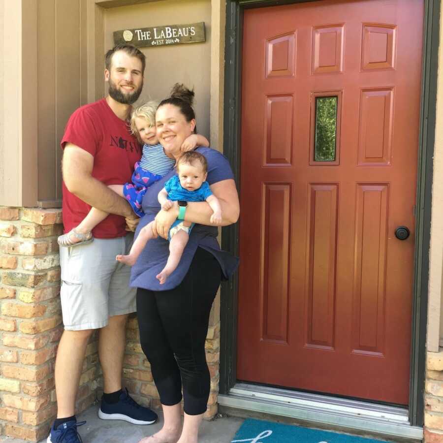 family taking a picture in front of door