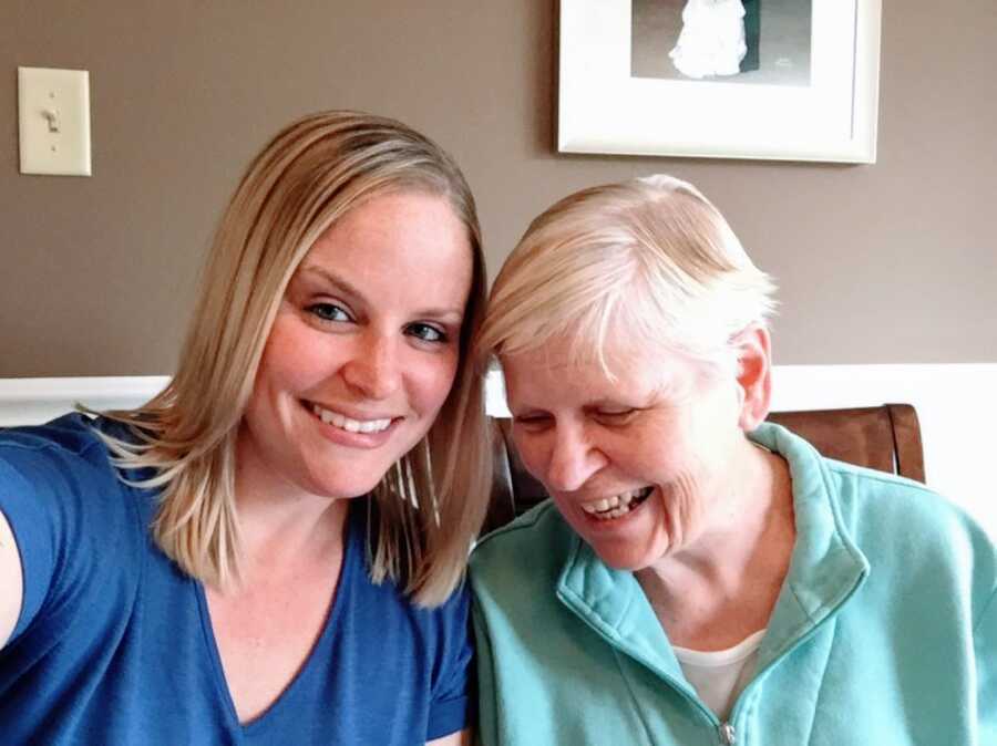 Woman in dark blue shirt takes a selfie with her mom battling Alzheimer's
