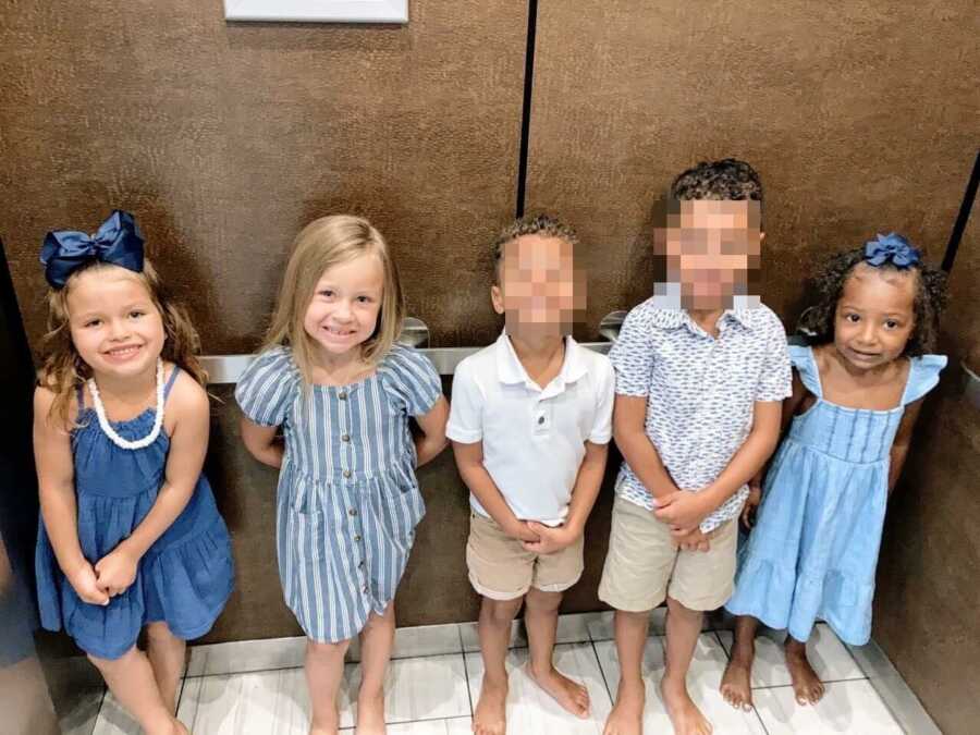 Foster kids smile for a photo while in an elevator in a hotel for vacation