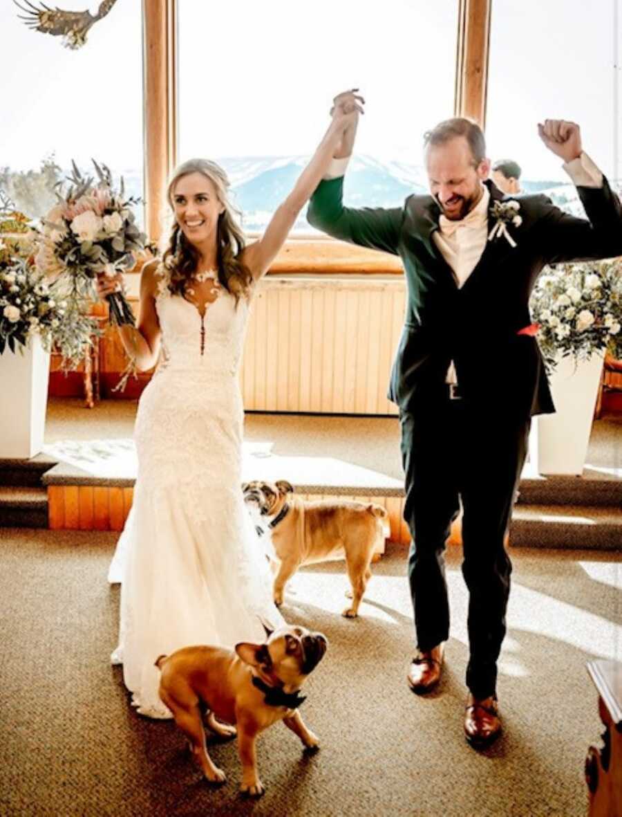 Newlyweds dance down the aisle to celebrate their love while their bulldogs chase after them
