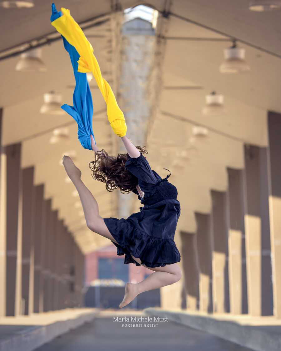 woman jumping in the air with ukraine colors