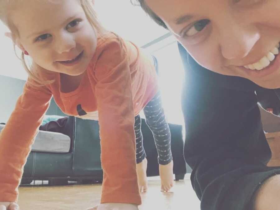 woman with her daughter doing yoga