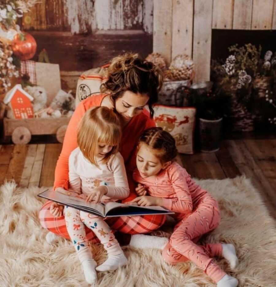 woman with her daughters reading to them