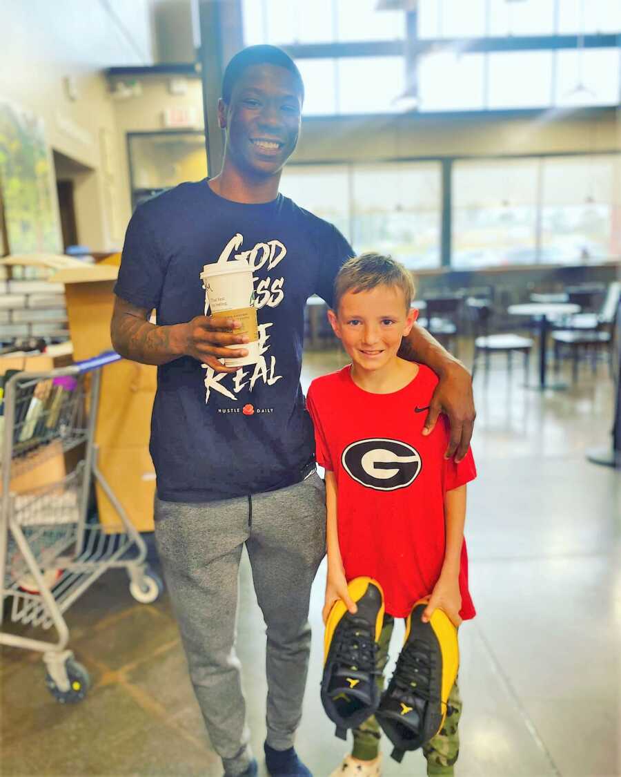 Young boy holding Jordan's shoes that the man standing next to them gifted him