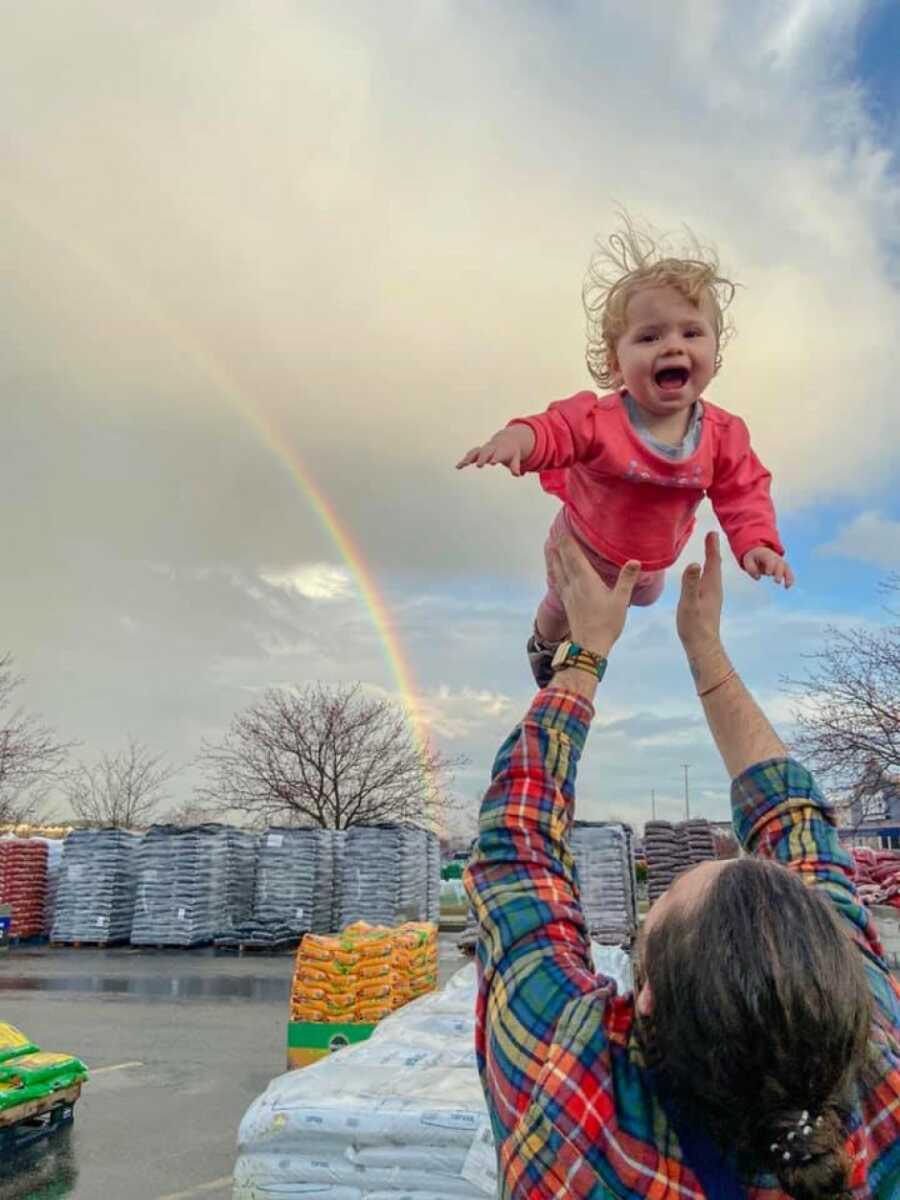 little girl being tossed in the air