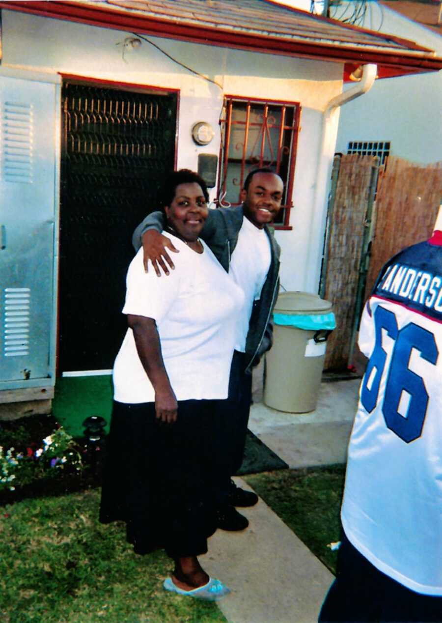 African American woman and her brother hugging outside of the entrance door of their house