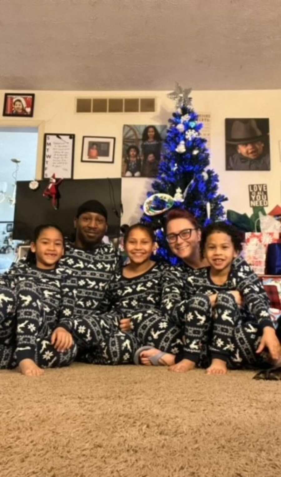 family photo in front of a christmas tree