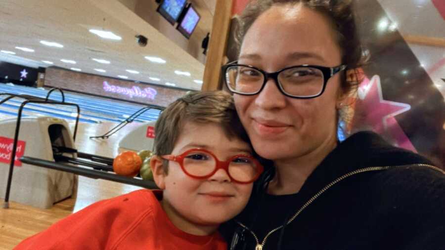 Mom and son take a selfie together while they're out for a family night of bowling