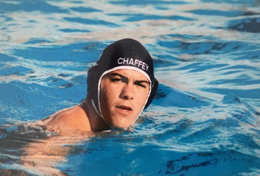 High school student looks serious while competing in a swim meet