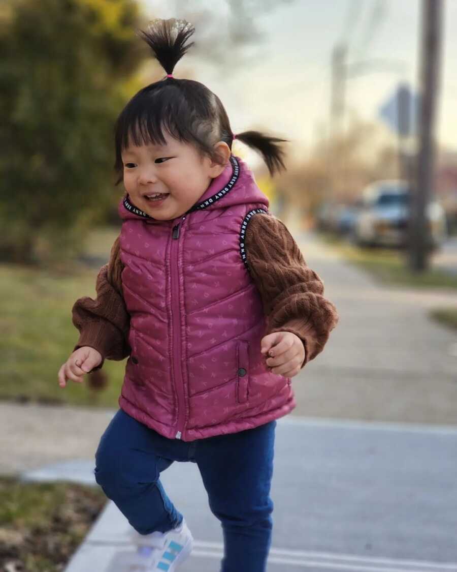 little girl smiling and walking
