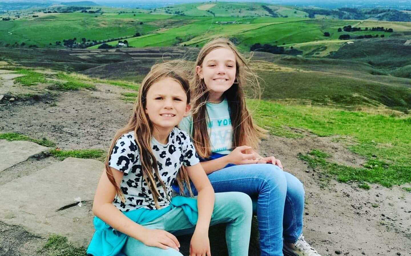 sisters sitting down on a hike