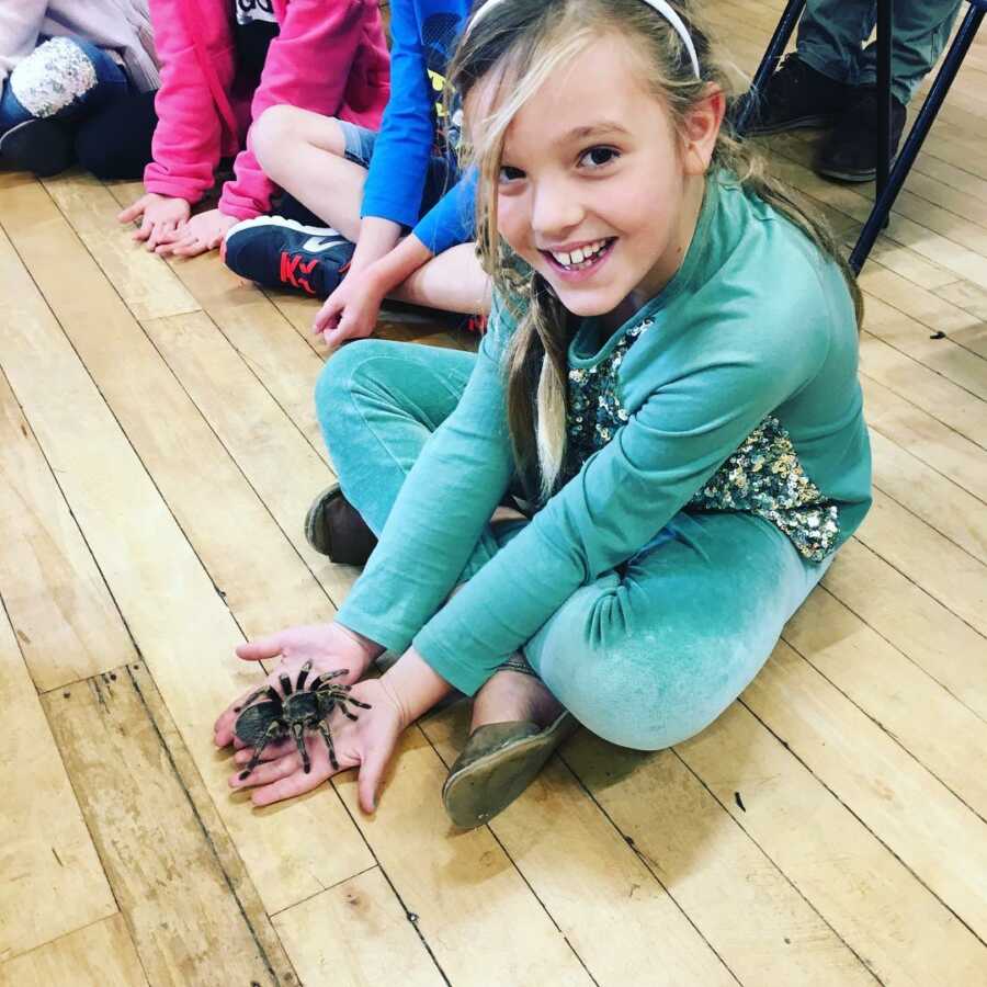 little girl holding a spider