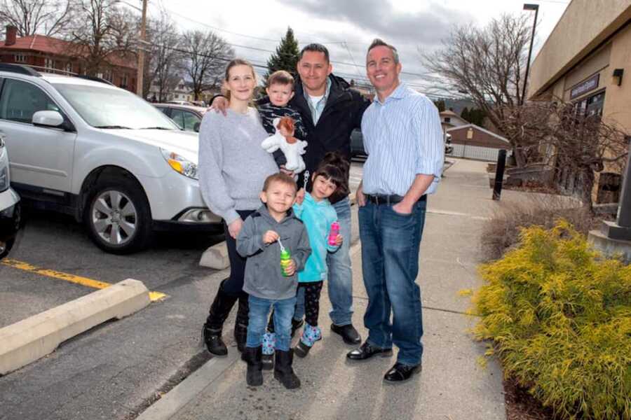 woman stands with her family and the man who saved her from her crashed car years prior