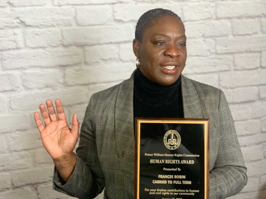 woman holding a plaque taking an oath