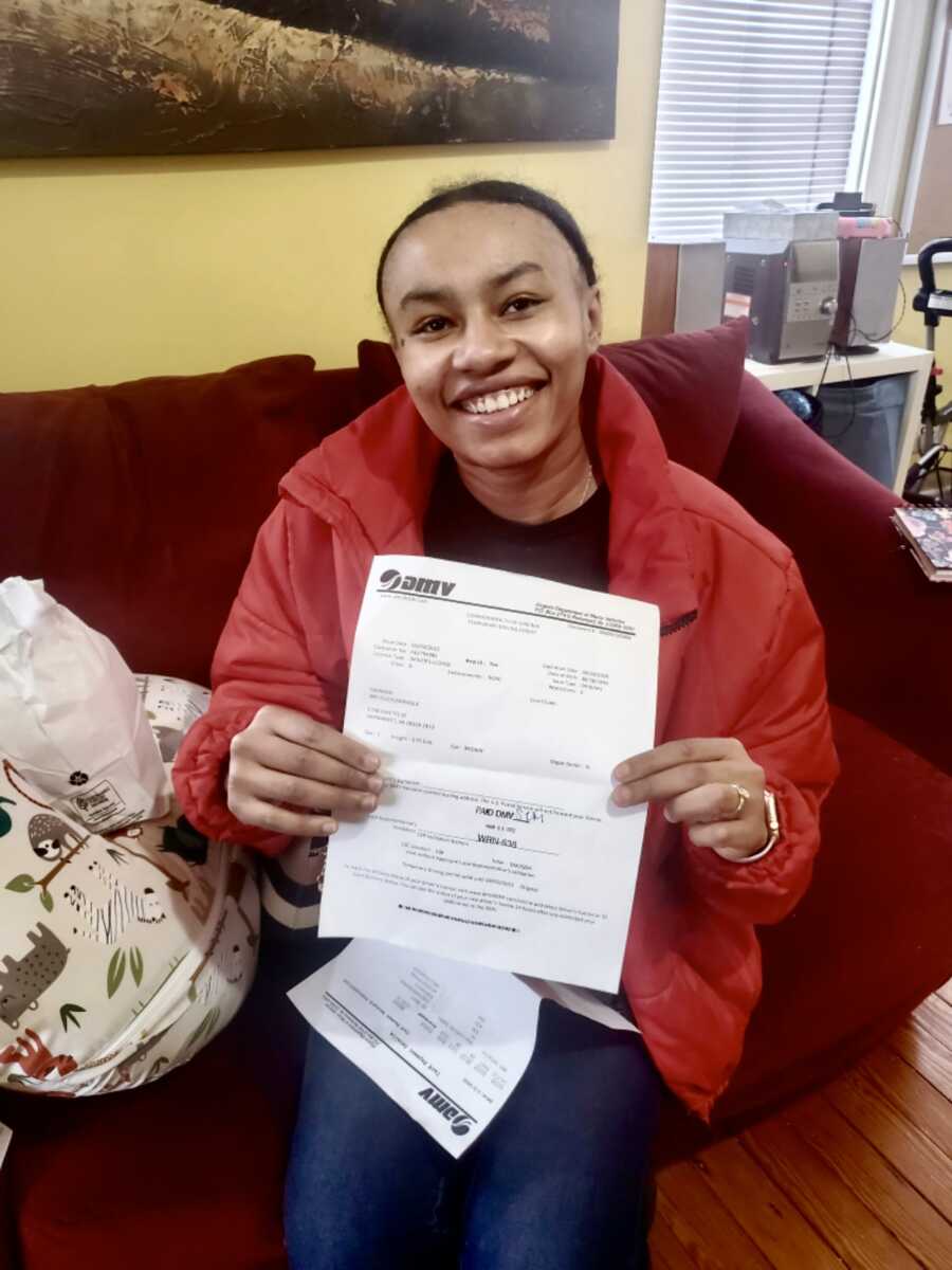 woman holding a piece of paper smiling